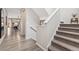 Staircase features carpeted steps, wood floors, and an open view to the living area at 19121 E 65Th Ave, Denver, CO 80249