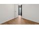 Another bedroom with wood floors, white walls, and a window with dark curtains at 575 2Nd St, Bennett, CO 80102