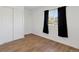 An additional bedroom features wood floors, a window with dark curtains, and a closet at 575 2Nd St, Bennett, CO 80102