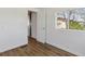A simple bedroom with hardwood floors, white walls, a window, and a white door at 575 2Nd St, Bennett, CO 80102