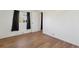 A simple bedroom with hardwood floors, a large window, and white walls at 575 2Nd St, Bennett, CO 80102