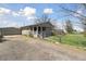 Charming home with a welcoming front porch, lush lawn, mature trees, and a detached garage at 575 2Nd St, Bennett, CO 80102