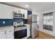 Well-equipped kitchen featuring stainless steel appliances, white cabinets, and a striking blue accent wall for a modern touch at 575 2Nd St, Bennett, CO 80102