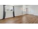 Spacious living area with new laminate flooring, white walls, and ample natural light from large windows with decorative curtains at 575 2Nd St, Bennett, CO 80102