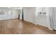 Bright living room featuring modern laminate flooring and fresh white walls, illuminated by natural light through draped windows at 575 2Nd St, Bennett, CO 80102