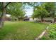 Spacious backyard featuring a well-maintained lawn, mature trees, storage sheds and garden beds ready for outdoor enjoyment at 10007 Bryant St, Denver, CO 80260