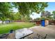 Spacious backyard with a well-kept lawn, wooden fence and shady trees, plus a patio with outdoor dining set at 10007 Bryant St, Denver, CO 80260