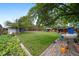 Large backyard with a well-kept lawn, wooden fence and shady trees, plus a patio at 10007 Bryant St, Denver, CO 80260