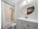 Bathroom with tile surround shower over tub and white vanity at 10007 Bryant St, Denver, CO 80260