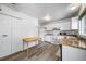 Bright kitchen with white appliances, light wood counters and luxury vinyl plank flooring at 10007 Bryant St, Denver, CO 80260