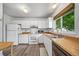 Bright kitchen with white appliances, light wood counters and luxury vinyl plank flooring at 10007 Bryant St, Denver, CO 80260