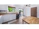 Functional kitchen with white cabinets, stainless steel sink, wood countertops, and access to a sliding patio door at 10007 Bryant St, Denver, CO 80260
