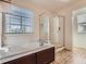 A bright bathroom showcases a large soaking tub next to a glass-enclosed shower at 4862 S Piccadilly Ct, Aurora, CO 80015