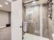 Bathroom shower with gray tile, glass door, and modern fixtures next to finished basement at 4862 S Piccadilly Ct, Aurora, CO 80015