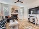 Cozy living room featuring a stone fireplace, comfortable seating, and a ceiling fan for added comfort at 4862 S Piccadilly Ct, Aurora, CO 80015
