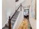 Well-lit staircase with carpeted steps, white railings, and views into the living area at 4862 S Piccadilly Ct, Aurora, CO 80015