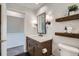 Bathroom with shelves, large mirror, and modern sink at 5648 S Youngfield Way, Littleton, CO 80127