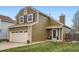 Two-story home featuring attached garage, manicured lawn and covered porch with comfortable seating at 5648 S Youngfield Way, Littleton, CO 80127