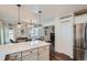 Modern kitchen with white countertops, stainless appliances, and view into the dining and living areas at 5648 S Youngfield Way, Littleton, CO 80127
