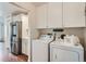 Bright laundry room features a washer, dryer, and white cabinets for ample storage at 5648 S Youngfield Way, Littleton, CO 80127