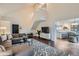 Open-concept living room with high ceilings, a modern sofa, and a view of the kitchen and staircase at 5648 S Youngfield Way, Littleton, CO 80127
