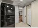 Hallway view of kitchen with brick wall and doorway to finished basement, and stainless refrigerator at 2716 N Vine St, Denver, CO 80205