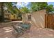 Stone patio with outdoor dining set surrounded by mature trees and lush greenery at 2716 N Vine St, Denver, CO 80205