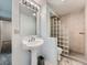 Cozy bathroom with a pedestal sink, decorative glass block, and a tiled shower stall at 4032 S Atchison Way, Aurora, CO 80014