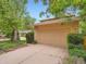 Home featuring an attached two-car garage with mature trees and shrubs in a landscaped front yard at 4032 S Atchison Way, Aurora, CO 80014