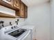 Modern laundry room features a washer, dryer, and overhead cabinets for storage at 4032 S Atchison Way, Aurora, CO 80014