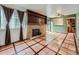 Cozy living room boasts a brick fireplace, large windows, and distinctive tile flooring at 4032 S Atchison Way, Aurora, CO 80014