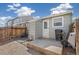 Backyard featuring a small patio, back door, wooden fence, and gravel at 8160 Washington St # 67, Denver, CO 80229