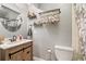 Charming bathroom featuring a wood vanity, round mirror, decorative plants, and soft gray walls at 8160 Washington St # 67, Denver, CO 80229