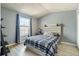 Serene bedroom with a plaid comforter, complemented by hardwood floors and a bright window at 8160 Washington St # 67, Denver, CO 80229
