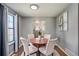 Cozy dining area with a round wooden table, upholstered chairs, and natural light from the window at 8160 Washington St # 67, Denver, CO 80229