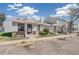 Quaint townhomes with brick accents, covered entries, and street parking on a sunny day at 8160 Washington St # 67, Denver, CO 80229