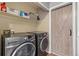 Functional laundry room features modern washer and dryer, ample storage, and a stylish barn door at 8160 Washington St # 67, Denver, CO 80229