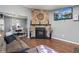Living room with stone fireplace, television, and view into dining area at 8160 Washington St # 67, Denver, CO 80229