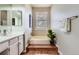 Bright bathroom featuring a bathtub and white cabinets with plenty of counter space at 8834 Blue Mountain Pl, Highlands Ranch, CO 80126