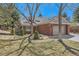 Charming brick home featuring mature trees, a well-manicured lawn, and an attached two-car garage at 8834 Blue Mountain Pl, Highlands Ranch, CO 80126
