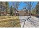 A well-maintained home with a long driveway, mature trees, and an attached two-car garage at 8834 Blue Mountain Pl, Highlands Ranch, CO 80126