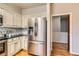 Modern kitchen featuring stainless steel refrigerator, custom cabinets, and an adjacent doorway at 8834 Blue Mountain Pl, Highlands Ranch, CO 80126