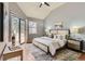Serene main bedroom featuring a vaulted ceiling, sliding glass doors to the deck, and modern décor at 8834 Blue Mountain Pl, Highlands Ranch, CO 80126
