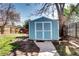 Charming backyard shed with white doors in fenced yard, perfect for storage at 3336 N Saint Paul St, Denver, CO 80205