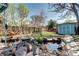 Private backyard featuring a rock garden with a pond, a bench, mature trees, and a blue shed at 3336 N Saint Paul St, Denver, CO 80205