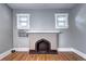 Close-up view of living room fireplace showcasing original brickwork, hardwood floors, and two windows at 3336 N Saint Paul St, Denver, CO 80205
