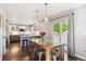 Dining area with a rustic wooden table, modern pendant lighting, and access to the patio at 1169 S Alton Ct, Denver, CO 80247