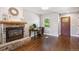 Cozy living room featuring a stone fireplace, hardwood floors, and a bright window at 1169 S Alton Ct, Denver, CO 80247