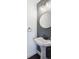 Charming powder room with a pedestal sink, decorative mirror, and modern lighting at 1169 S Alton Ct, Denver, CO 80247