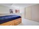 This light-filled bedroom features a blue comforter, ample closet space and neutral carpeting at 12780 E Bethany Pl, Aurora, CO 80014